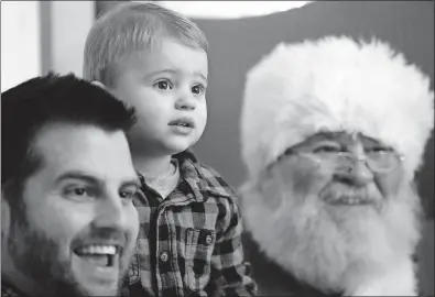  ?? [FRED SQUILLANTE/DISPATCH PHOTOS] ?? Kade Wolfe, 2, and his dad, Ryan Wolfe, get their picture taken with Santa at Snowflake Castle in Westervill­e on Saturday.