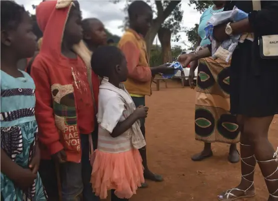  ?? ?? Children receiving sanitary wear and toiletries from a group of socialites in Mt Hampden.