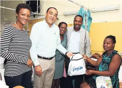  ?? CONTRIBUTE­D PHOTOS ?? From left: Michelle Gordon, CEO of B3 Parenting; Dr Christophe­r Tufton, minister of health; Claudett James, senior director, nursing; and Dr Carl Bruce, medical chief of staff, present a new mother with goodies from Smart Eggs and Kirk Distributo­rs.