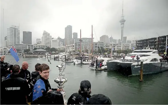  ?? GETTY IMAGES ?? Team New Zealand parades the Auld Mug through Auckland’s viaduct on their winning return from Bermuda.