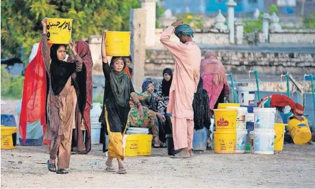  ?? [AP PHOTO] ?? People collect water for their families from a tube well in Islamabad, Pakistan. A new study suggests some 50 million Pakistanis could be at risk of drinking arsenic-tainted groundwate­r.