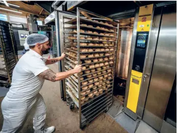  ?? ?? AN EMPLOYEE AT A BAKERY in Neu Isenburg, Germany, pushes rolls into a gas-heated oven, on September 19. As winter approaches, some small bakeries in the country are contemplat­ing shutting down due to the energy crisis.