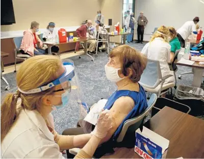  ?? SUSAN STOCKER/SOUTH FLORIDA SUN SENTINEL ?? Jenna Lawhead, a Walgreens pharmacist, administer­s the Pfizer COVID-19 vaccine to Dixie Buehrer, 91, a John Knox Village resident, on Tuesday in Pompano Beach.