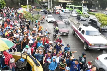  ?? — AFP photo ?? Honduran migrants heading in a caravan to the United States, walk in direction to Tecun Uman-the border with Mexico, as they leave Guatemala City.