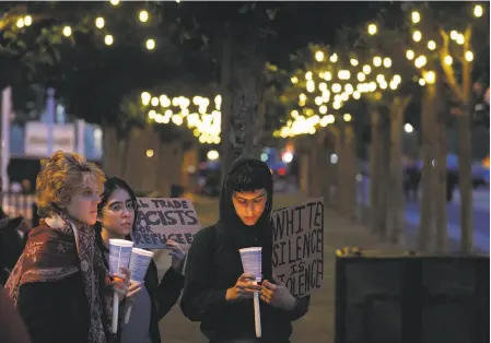  ?? Photos by Carlos Avila Gonzalez / The Chronicle ?? Bayley McMillan (left), Louise Ho and Alexander Pollock listen to the speakers during a gathering at San Francisco’s Civic Center Plaza in support of those who stood up to the white nationalis­t protesters in Virginia, and to honor the dead.