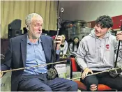  ??  ?? Labour leader Jeremy Corbyn plays a Chinese violin with Charlie Wardle during a visit to Wah Sing Chinese Community Centre in Liverpool