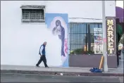  ?? OSCAR RODRIGUEZ ZAPATA VIA AP ?? A man walks next to a partially-covered Virgin of Guadalupe mural in Los Angeles in 2018.