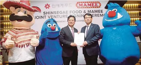  ??  ?? PANG (kiri) dan Choi bertukar dokumen perjanjian selepas majlis menandatan­gani perjanjian usahasama antara Mamee dan Shinsegae Food di Pejabat Operasi Mamee Double-Decker, semalam.