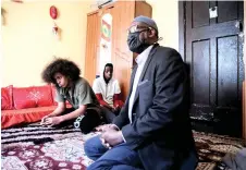  ?? — AFP photo ?? An Oromo-Ethiopian community leader, Musa Jibro (right), sits in a house in Johannesbu­rg, as he speaks with an Oromo undocument­ed family about the problems they are currently facing due to the national lockdown to prevent the spread of the Covid-19 coronaviru­s.