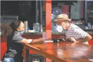  ??  ?? Waitress Asia Banks ( left) discusses the lunch menu at Oakland’s Plank with customer Ben Lang.