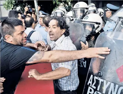  ??  ?? OWE, NO! Protests rage in Athens against a proposed EU bailout, even amid ongoing daily cash limits.