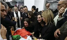  ?? Photograph: Abbas Momani/AP ?? Colleagues and friends react as the Palestinia­n flag-draped body of Shireen Abu Akleh is brought to the news channel's office in the West Bank city of Ramallah in May.