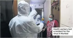  ??  ?? Health workers test a resident for the virus in Mumbai