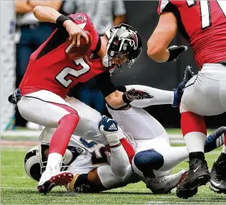  ?? CURTIS COMPTON / CCOMPTON@AJC.COM ?? Matt Ryan is wrapped up by the Rams’ Dante Fowler Jr. in the first of two back-to-back sacks during the first quarter Sunday. Ryan later left with a high ankle sprain.