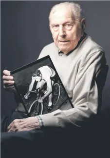  ?? — AFP photo ?? Coste, poses with a photo of himself when he was competing during a photo session at home in Bois-Colombes, northweste­rn of Paris.