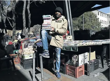  ??  ?? Blessing Taskatsa’s book stall at the Joubert Street market is wedged between a bead stall and a food vendor selling chips and nuts.