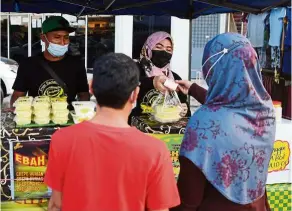  ?? — Bernama ?? Norhabibah tending to customers at the Taman Cenderawas­ih night market in Kuantan.