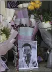  ?? CHINATOPIX VIA AP ?? Flowers are placed near a photo of Dr. Li Wenliang at a hospital in Wuhan in central China’s Hubei province. Li, 34, died of the coronaviru­s on Friday.