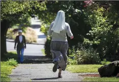  ?? Seattle Times (TNS)/ELLEN M. BANNER ?? Novice Mary Lopez runs through Ballard, a neighborho­od of Seattle. It’s not the six to nine miles a day, but her running outfit — a habit — that has some residents doing a double take in passing.