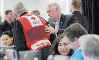  ?? Susan Walsh ?? The Associated Press Vice President Mike Pence speaks with workers during a visit Sunday to the Federal Emergency Management Agency headquarte­rs in Washington.