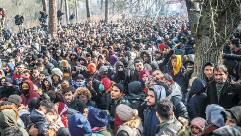  ??  ?? REFUGEES GATHER at the buffer zone between the Pazarkule border gate at Edirne, Turkey, and the Kastanies border gate in the Evros region of Greece, as they try to enter Greece, on February 29.