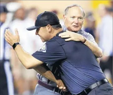  ?? Ross D. Franklin
Associated Press ?? STEVE SARKISIAN, front, hugs USC Athletic Director Pat Haden before the team’s Sept. 26 game against Arizona State in Tempe. Haden’s decision not to discipline Sarkisian after an August incident drew criticism.