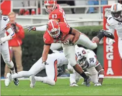  ?? John Bazemore/AP ?? Georgia running back Nick Chubb (27) breaks away from Auburn defenders T.J. Davis (13) and Tre' Williams (30).