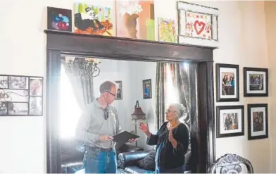  ?? AAron Ontiveroz, The Denver Post ?? Ralph Yatsko, program manager for Energy Outreach Colorado, speaks with Brenda Lovato at her home this month. Before the Interstate 70 project heads to constructi­on, the city and CDOT are spending millions of dollars to reduce sound and dust for more than 250 homes within a block of the freeway.