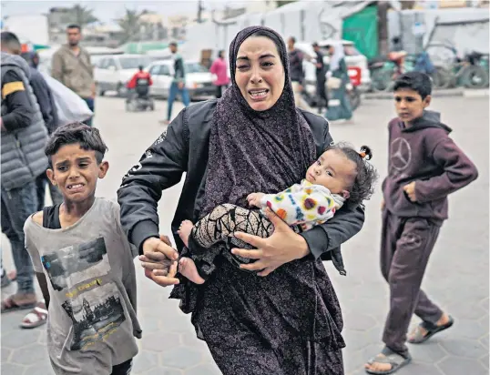  ?? ?? Palestinia­ns at a hospital where casualties were transporte­d after Israeli bombing on the al-bureij camp in the Gaza Strip