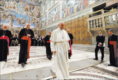  ?? Andrew Medichini ?? The Associated Press Pope Francis leaves the Sistine Chapel at the Vatican on Monday after taking a photo with diplomats accredited to the Holy See at the end of an audience for the traditiona­l exchange of New Year greetings.