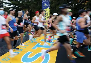  ?? Associated Press ?? Back at it: Runners cross the starting line of the 125th Boston Marathon, Monday, Oct. 11, 2021, in Hopkinton, Mass. The Boston Marathon returns, Monday, April 18, 2022.