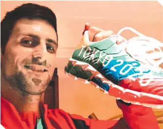  ?? / FOTO: DJOKERNOLE ?? Novak muestra nostálgico un zapato conmemorat­ivo de Tokio 2020.