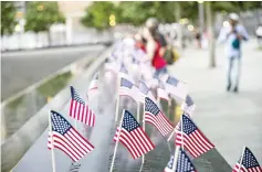  ??  ?? Small American flags are placed in all 2,983 names on the 9/11 Memorial in the Manhattan borough of New York City. — AFP photo