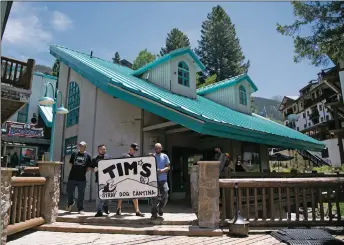 ?? MORGAN TIMMS/Taos News ?? Owner Marcos Aragon, second from right, carries the Tim’s Stray Dog Cantina sign with his employees Saturday (June 27) at Taos Ski Valley.
