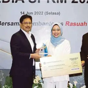  ?? (Foto Mohd Fadli Hamzah/bh) ?? Azam menyampaik­an anugerah utama kategori media cetak kepada Suzalina pada Majlis Anugerah Media SPRM 2022 di Putrajaya, baru-baru ini.