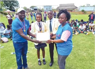  ?? ?? Mr Walter Mafundikwa (left), Lynnette Chodokufa and Shemeiah Jonga from Masuka Christian High School receive exercise books from Zimpapers public relations and communicat­ions manager Pauline Matanda (right). The books were also handed out to learners from different schools that took part in the cancer power walk, courtesy of the Zimpapers' Commercial Printing Division