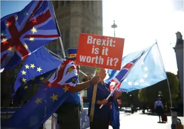  ??  ?? Anti-brexit protestors wave flags outside the Houses of Parliament in London, Britain. Most British companies will implement their plans for coping with a disruptive Brexit by December if there is no clarity by then on how Britain will leave the EU, a survey by a major employers group showed. – Reuters photo