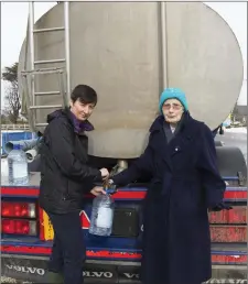  ??  ?? Margaret O’Regan and St Stephen at a water tanker in Ramsgrange during the recent Storm Emma.