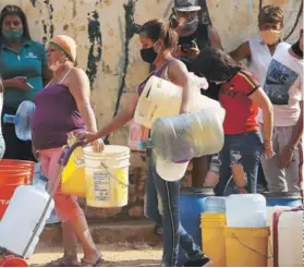  ??  ?? ► Venezolano­s hacen fila para cargar agua en bidones en Caracas.