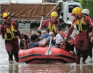  ?? /Reuters ?? City life: Firefighte­rs rescue people on a flooded street after heavy rains in Vila Leopoldina neighbourh­ood in Sao Paulo in February 2020. Concrete-filled urban areas are increasing heat absorption, which creates heavier rains than in previous years.