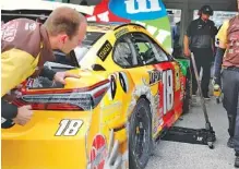  ?? AP PHOTO/TERRY RENNA ?? A crew member looks at a scrape on the rear of Kyle Busch’s car during practice Saturday for today’s NASCAR Cup Series race at Homestead-Miami Speedway in Florida.