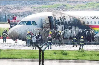  ?? REUTERS PIC ?? Rescue workers at the site where an Airbus A319 of Tibet Airlines caught fire after an aborted take-off at Chongqing Jiangbei Internatio­nal Airport in Chongqing, China, yesterday.