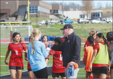  ?? Daniel Bereznicki/McDonald County Press ?? Lady Mustang soccer head coach Nathan Haikey gives goalie Joslyn Royce a high five during the MCHS soccer jamboree.