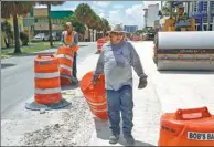  ?? JOE SKIPPER / THOMSON REUTERS FOUNDATION ?? Workers Rai Finalet and Eduardo Malde (left) move constructi­on barriers in Miami, Florida, which is at growing risk of extreme heat.