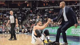  ??  ?? Memphis Grizzlies center Marc Gasol (33) is helped to his feet by interim head coach J.B. Bickerstaf­f after being fouled. YALONDA M. JAMES/THE COMMERCIAL APPEAL