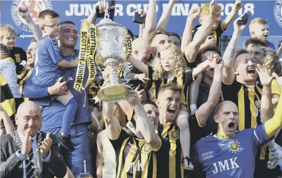  ??  ?? 2 Gordon Pope lifts the trophy for Auchinleck after a dramatic finish to the Scottish Junior Cup final at Rugby Park yesterday.