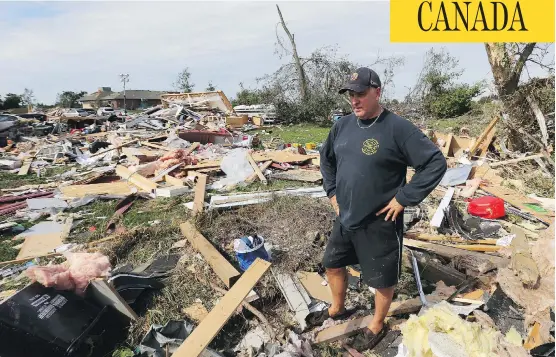  ?? JEAN LEVAC / POSTMEDIA NEWS ?? Brian Lowden takes a moment to collect himself while surveying the wreckage of his home on Sunday in Dunrobin, Ont., just outside Ottawa.