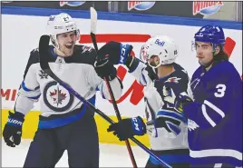  ?? CP PHOTO FRANK GUNN ?? Winnipeg Jets’ Nikolaj Ehlers (27) celebrates his goal against the Toronto Maple Leafs with teammate Mathieu Perreault (85) as Maple Leafs’ Justin Holl (3) skates past during first period NHL hockey action in Toronto on Thursday.