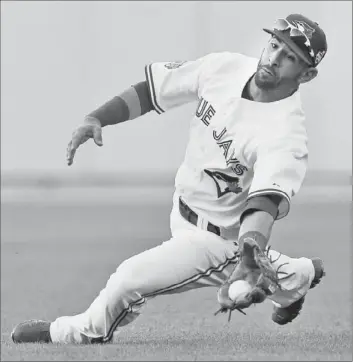  ?? Charlie Riedel Associated Press ?? KNOWN MORE for his bat, Toronto’s Jose Bautista robs Milwaukee’s Ryan Braun in the second inning.