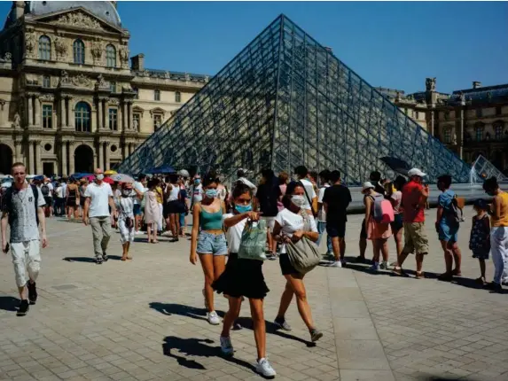  ??  ?? Masked tourists outside the Louvre in Paris yesterday (AP)
